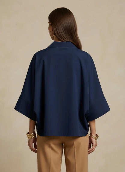 Person wearing a navy blue shirt and beige pants against a beige background