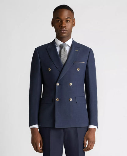 Man wearing a navy blue suit with gold buttons on a light gray background