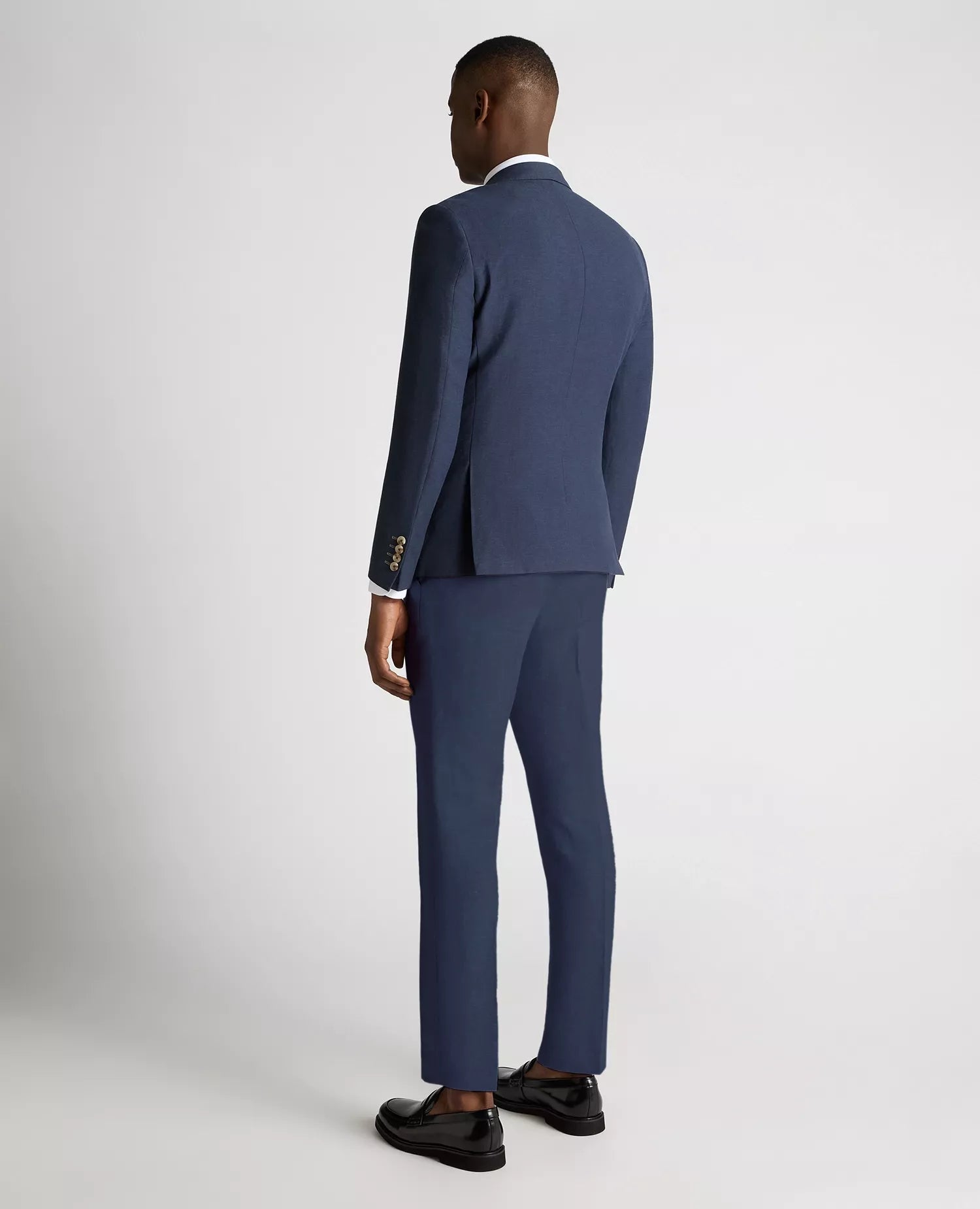 Man wearing a blue suit standing against a white background