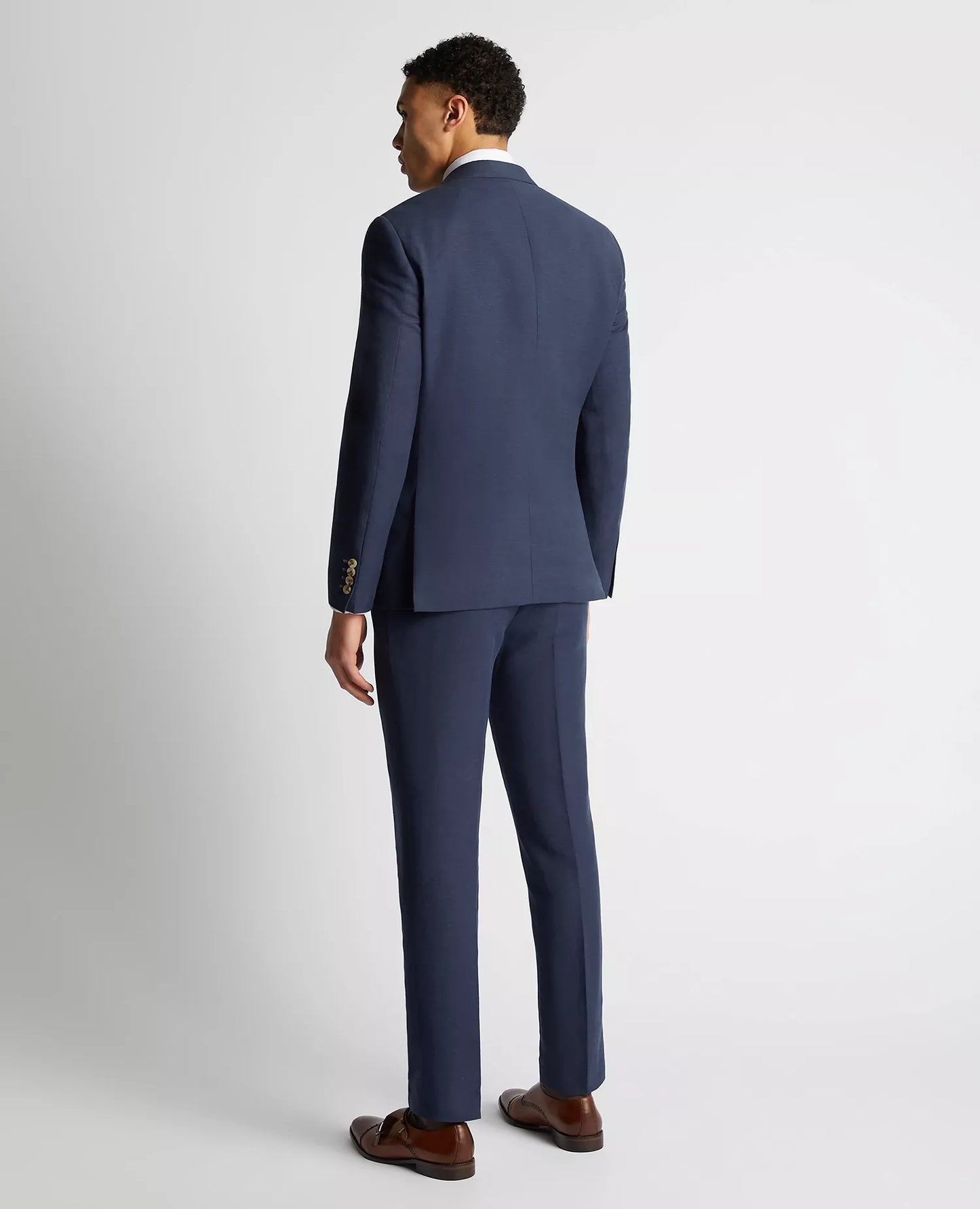 Man wearing a blue suit standing against a white background