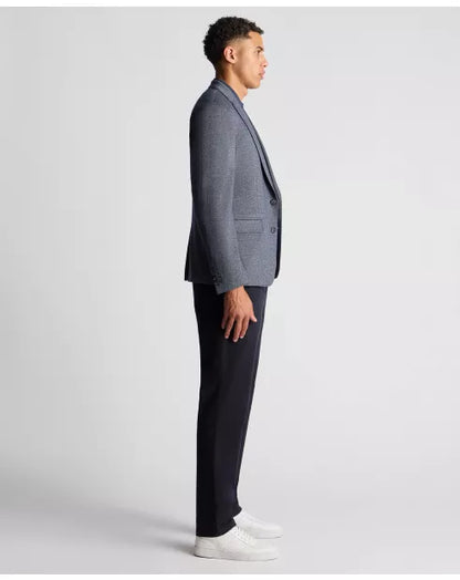 Man wearing a gray blazer and black pants on a white background