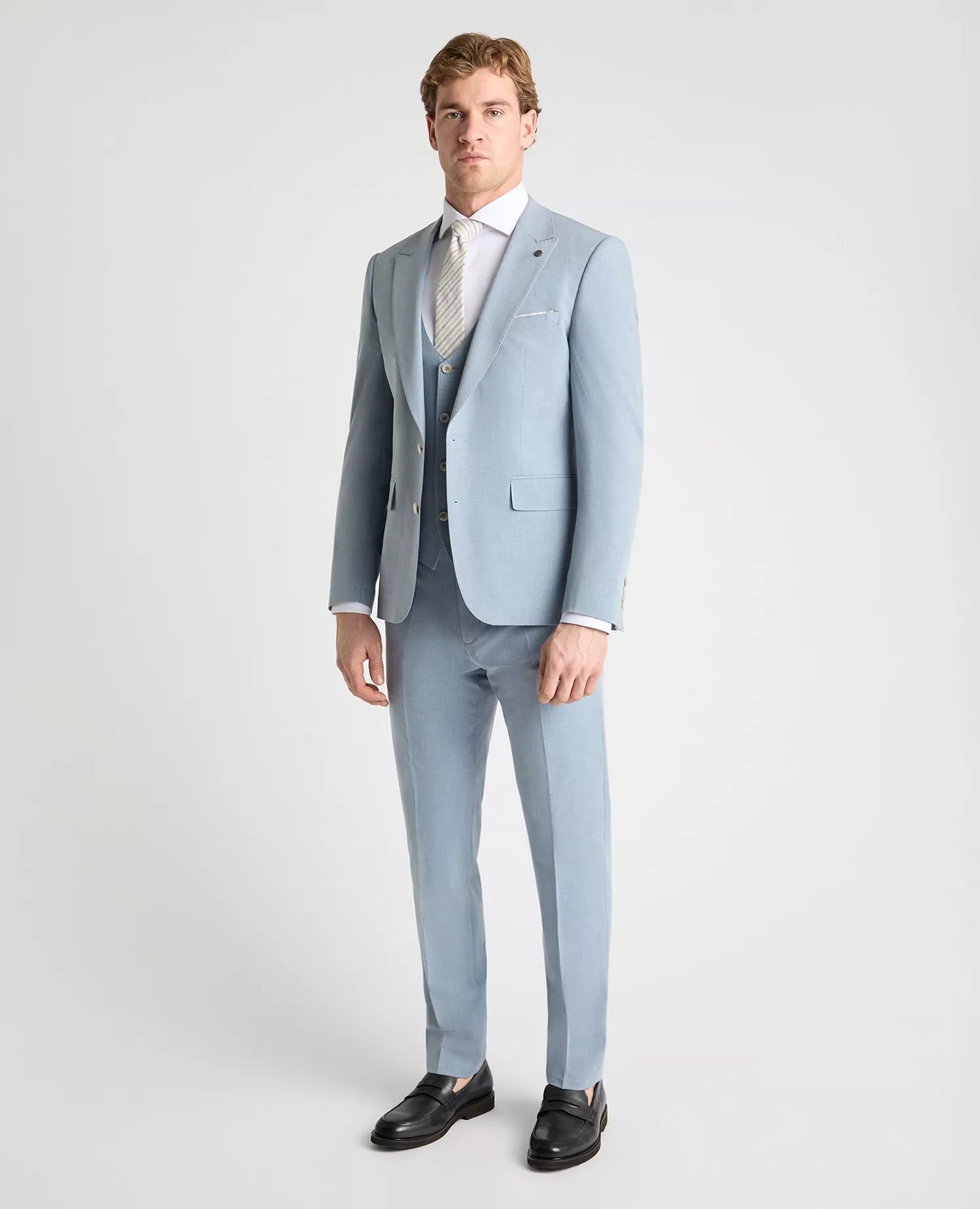 Man wearing a light blue suit with a white shirt and tie on a white background