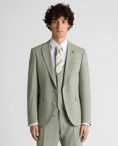 Man wearing a light green suit with a white shirt and patterned tie on a plain background