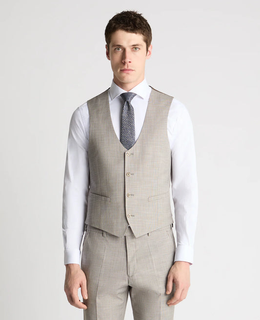 Man wearing a gray checkered vest over a white shirt with a patterned tie on a light gray background