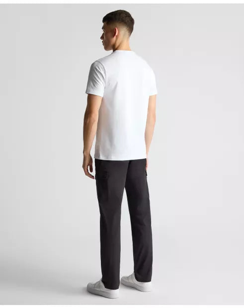 Man wearing a white t-shirt and black pants on a light gray background