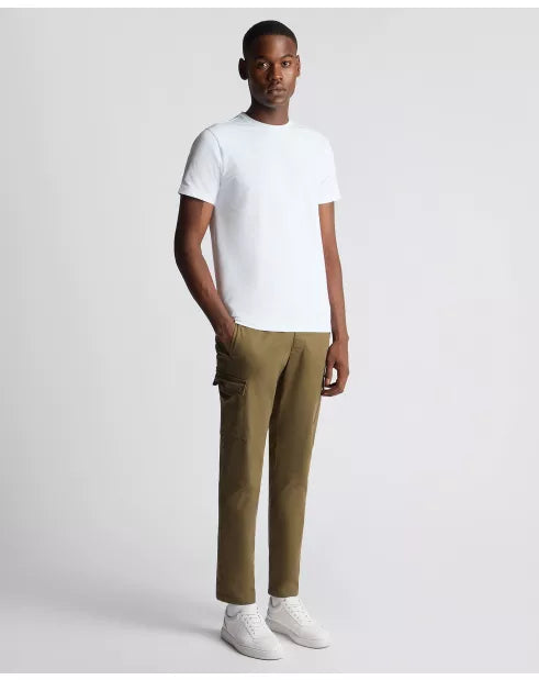 Man wearing a white t-shirt and olive green pants on a light gray background