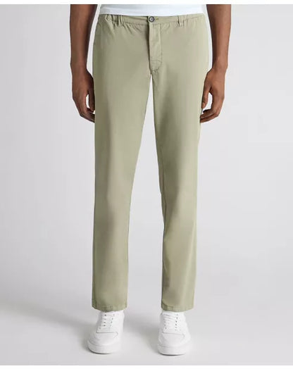 Person wearing light green pants and white sneakers on a white background
