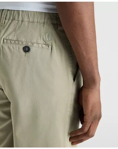 Close-up of beige pants with a button on a white background