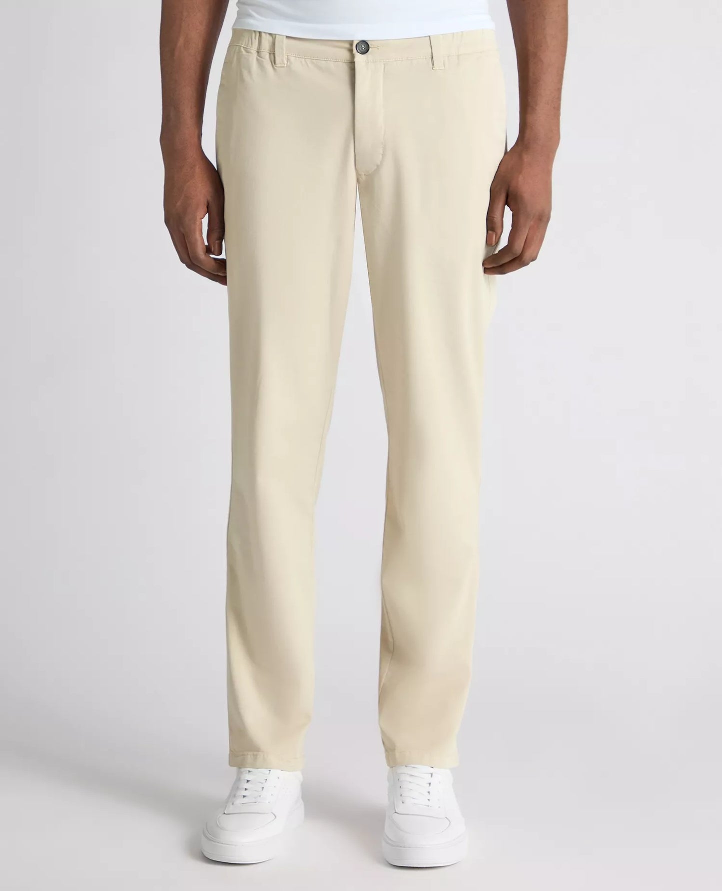 Beige pants worn by a person on a white background