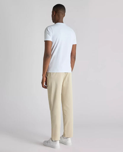 Man wearing a white t-shirt and beige pants on a light gray background