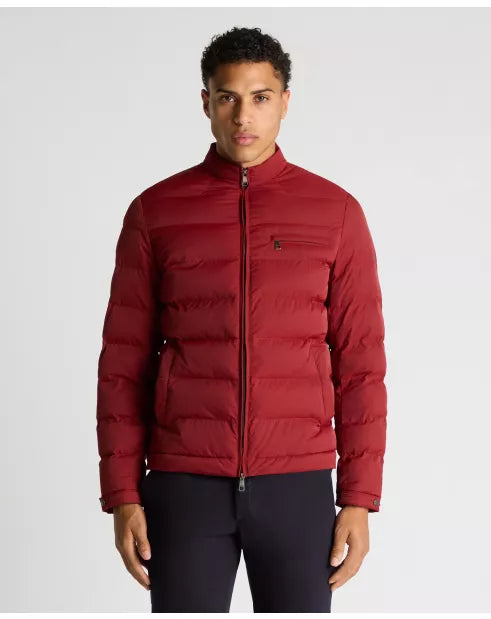 Man wearing a red puffer jacket on a light gray background