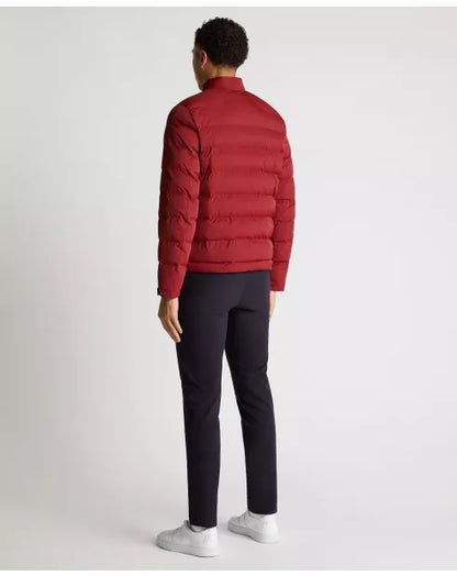 Person wearing a red puffer jacket and black pants on a white background