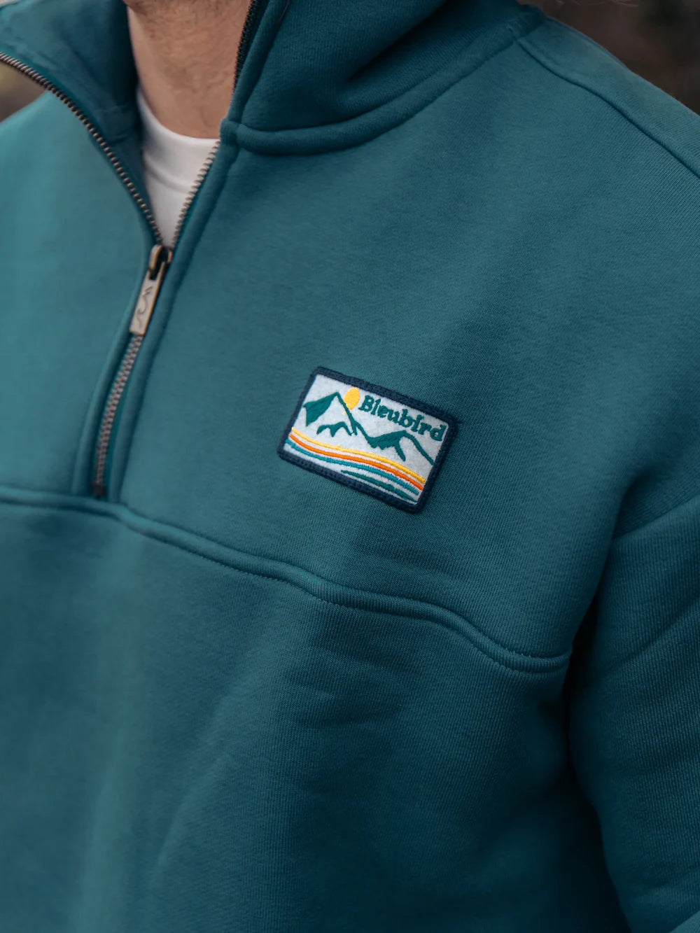 Teal hoodie with a brand logo on the chest