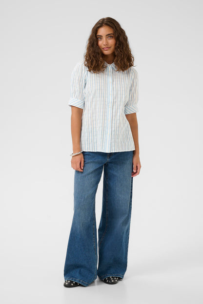 Woman wearing a white striped shirt and blue jeans on a white background