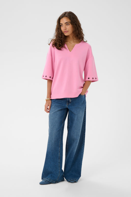 Woman wearing a pink blouse and blue jeans on a white background