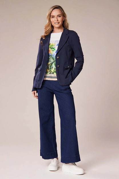 Woman wearing a navy blue suit with a colorful top on a beige background