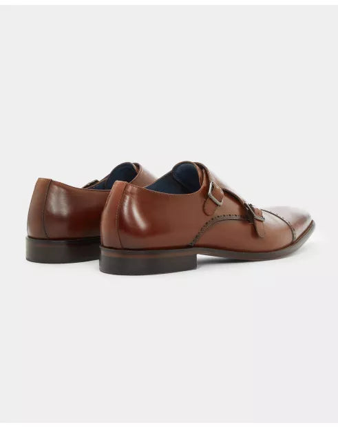 Pair of brown leather shoes with a strap on a white background