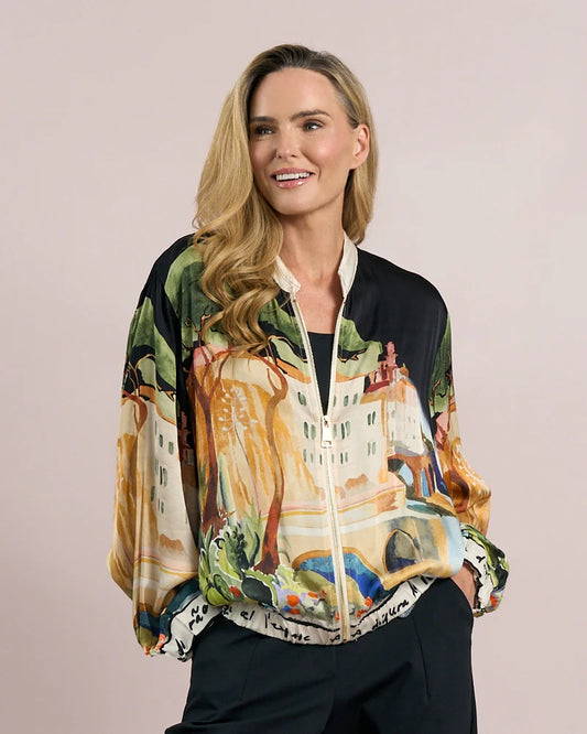 Woman wearing a colorful jacket with artistic design on a plain background