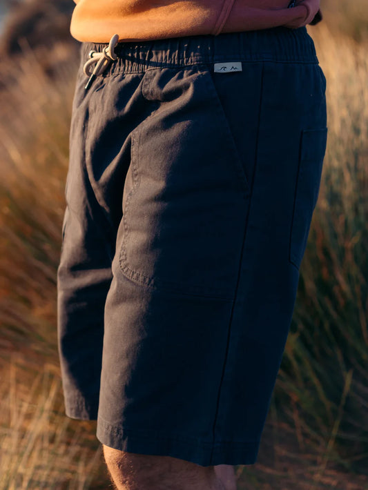 Person wearing dark shorts with a blurred natural background