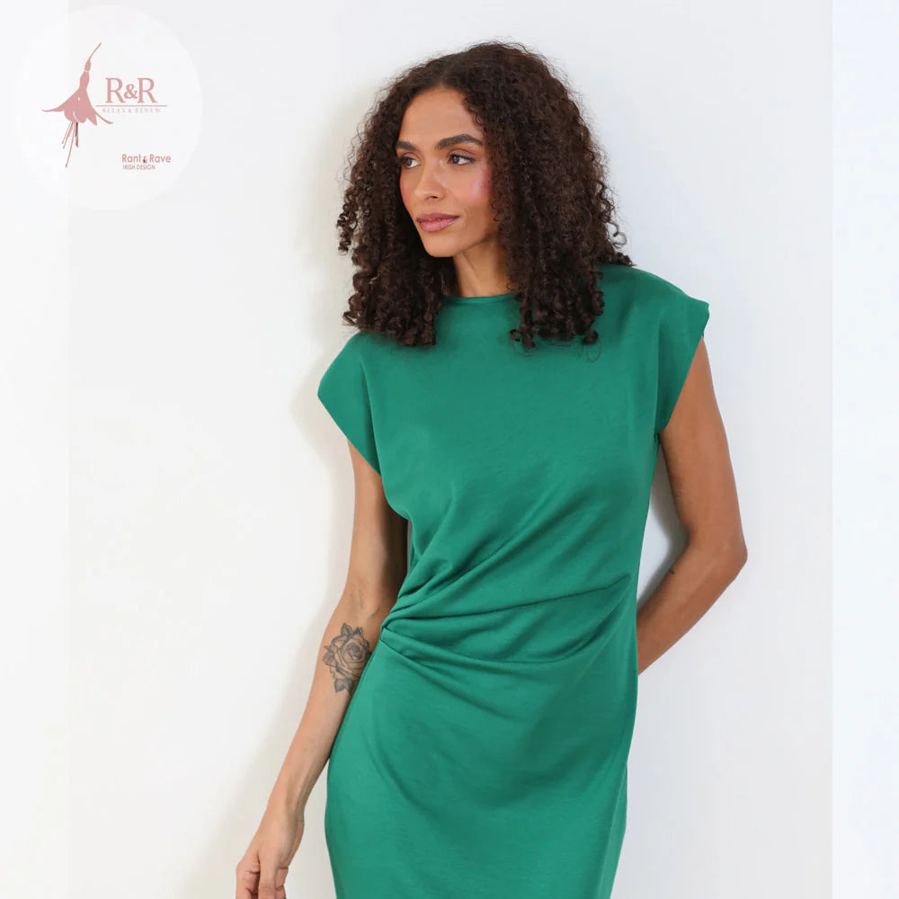 Woman wearing a green dress against a white background with 'R&R' branding.