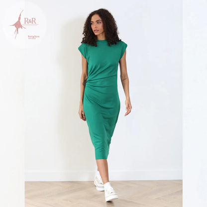 Woman wearing a green dress against a white background with 'R&R' branding.