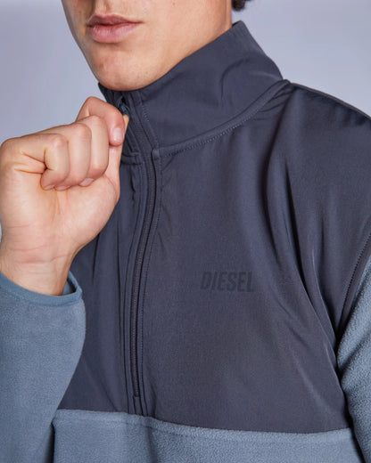 Close-up of a person wearing a gray jacket with 'DIESEL' branding.