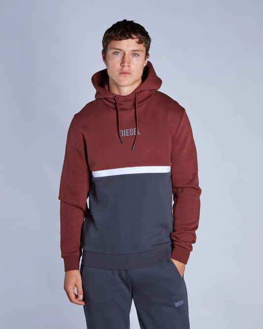 Man wearing a two-tone hoodie with 'Diesel' branding on a plain background