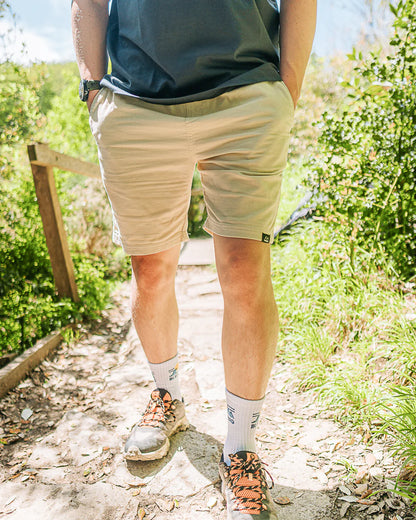 Person wearing beige shorts and hiking shoes on a nature trail