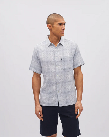Man wearing a checkered shirt and shorts on a plain background