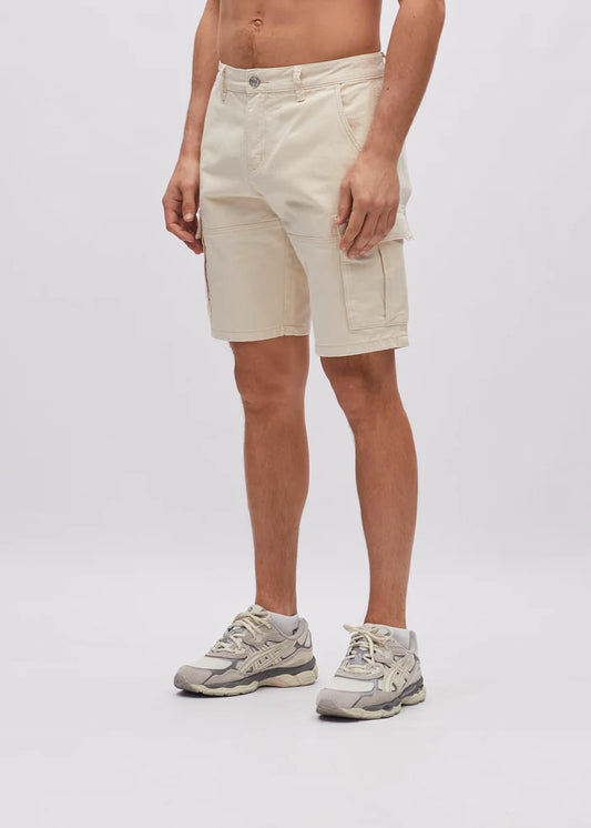 Person wearing beige shorts and sneakers on a white background