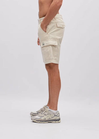 Person wearing beige cargo shorts on a plain background