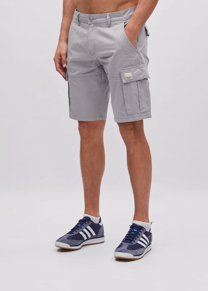 Person wearing gray cargo shorts and blue sneakers on a white background