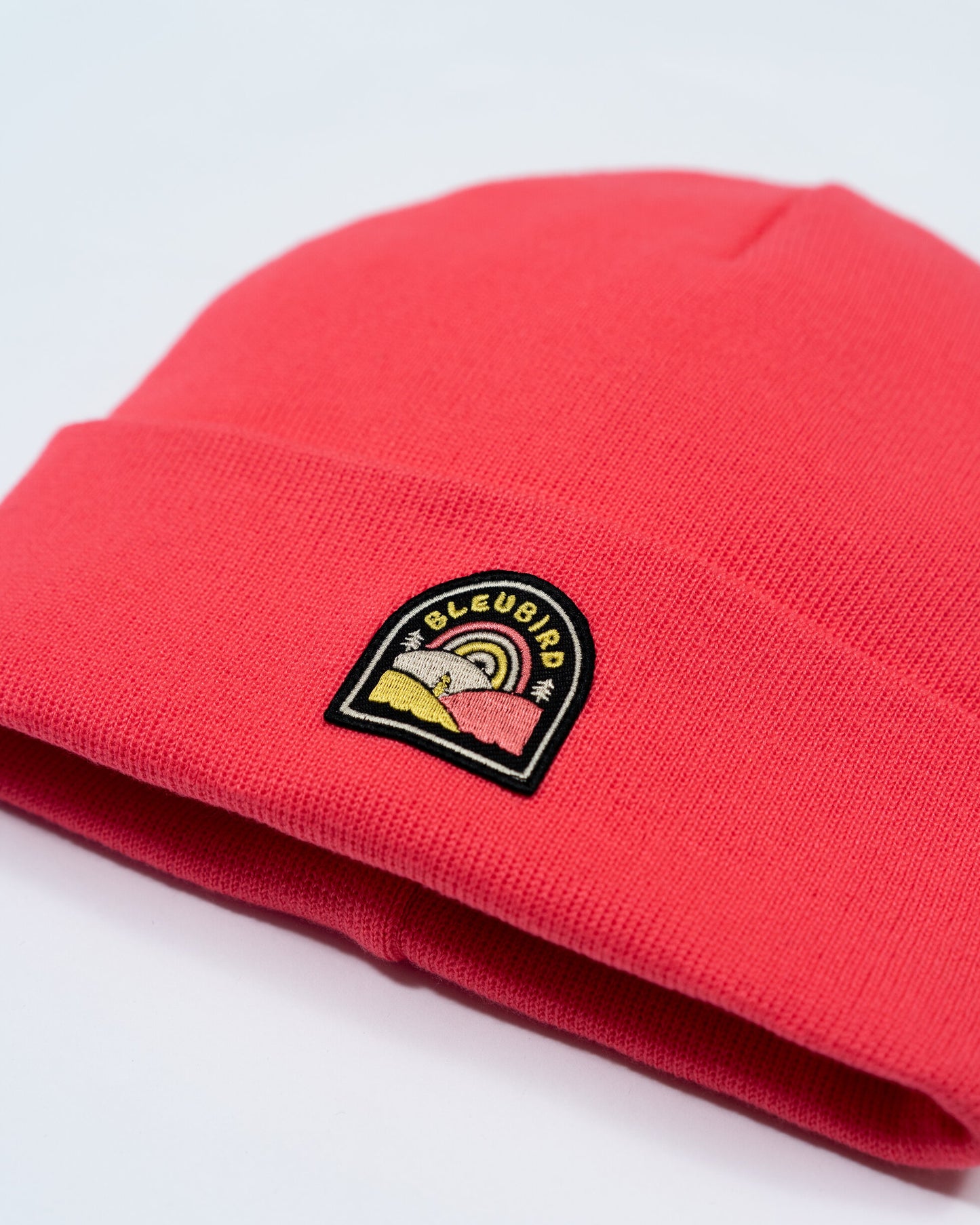Red beanie with a logo on a light gray background