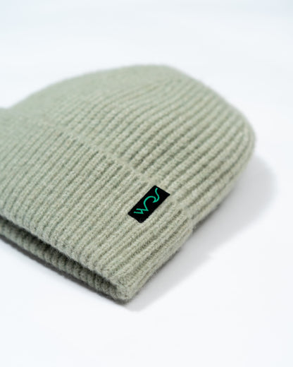 Green beanie with a logo on a white background