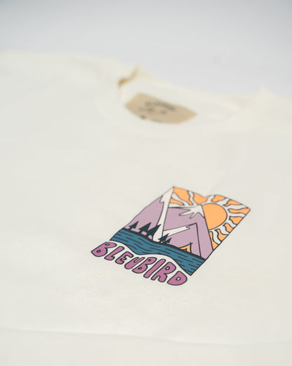 White t-shirt with colorful graphic design and 'BLEUBIRD' text on a light gray background