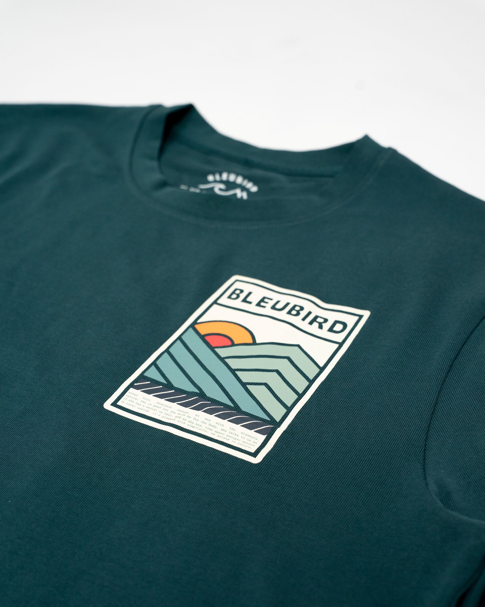 Green t-shirt with a graphic design and 'BLEUBIRD' branding on a white background
