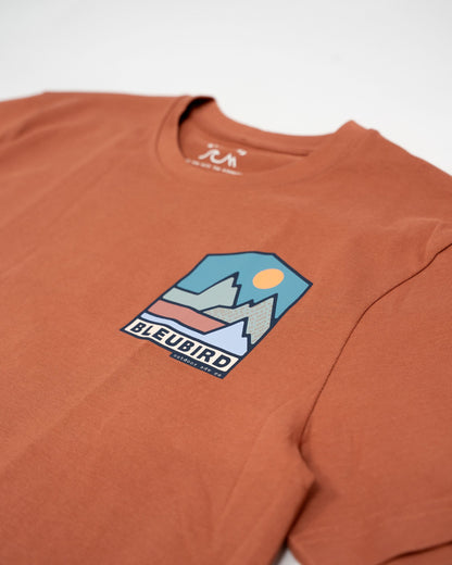 Brown t-shirt with a graphic design and 'BLEUBIRD' branding on a white background
