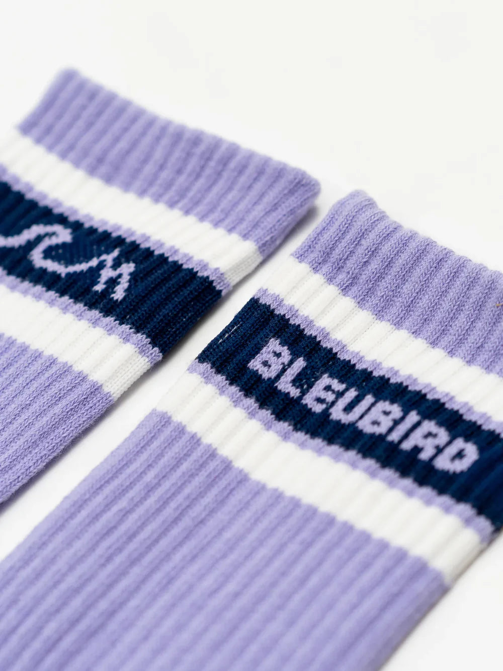 Pair of purple socks with blue and white accents on a white background