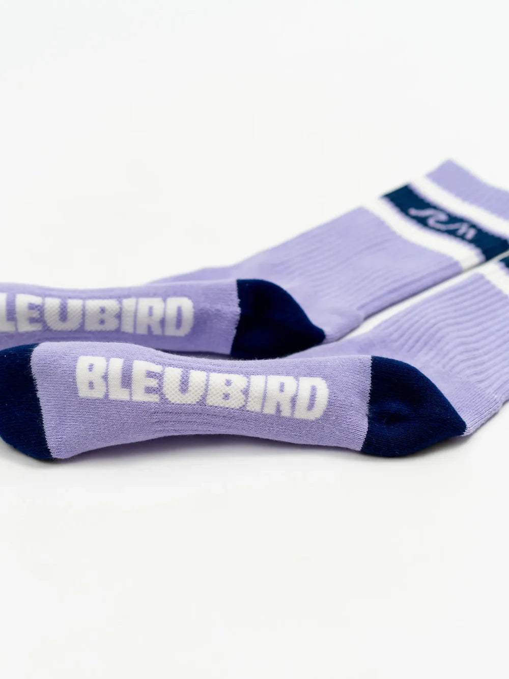 Pair of purple socks with 'BLEUBIRD' branding on a white background