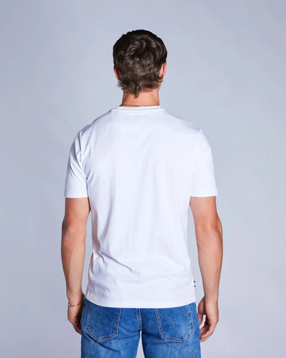 Man wearing a plain white t-shirt and blue jeans against a light gray background