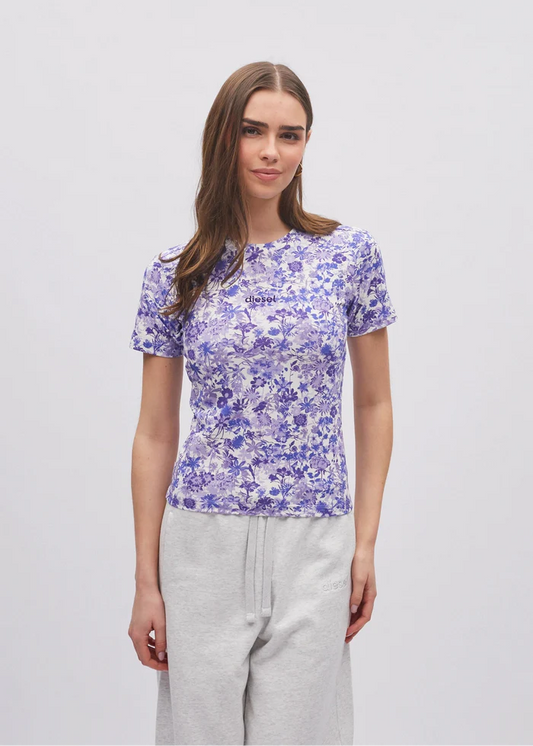 Woman wearing a purple floral t-shirt with a visible brand logo on a light gray background