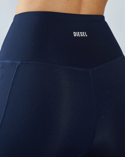 Navy blue pants with Diesel logo on a plain background