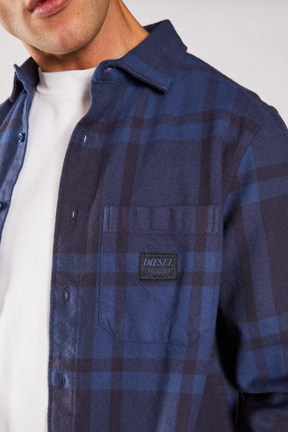 Blue plaid shirt with a Diesel logo patch on a white background