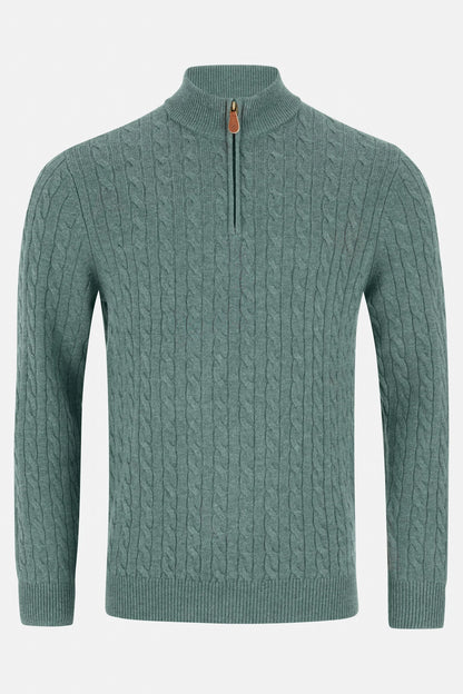 Green cable knit sweater with a quarter zip on a light gray background