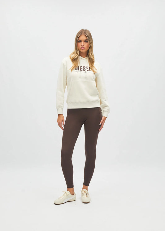 Women modelling against plain background cream hoodie with logo and brown leggings