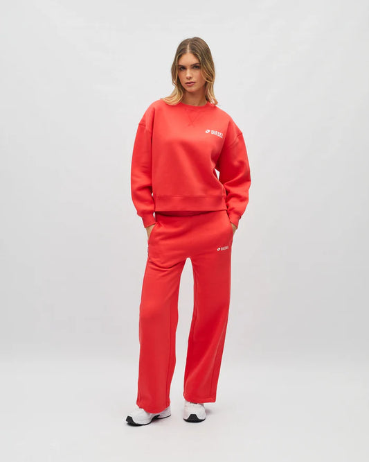 Person wearing a red tracksuit with a brand logo on a white background