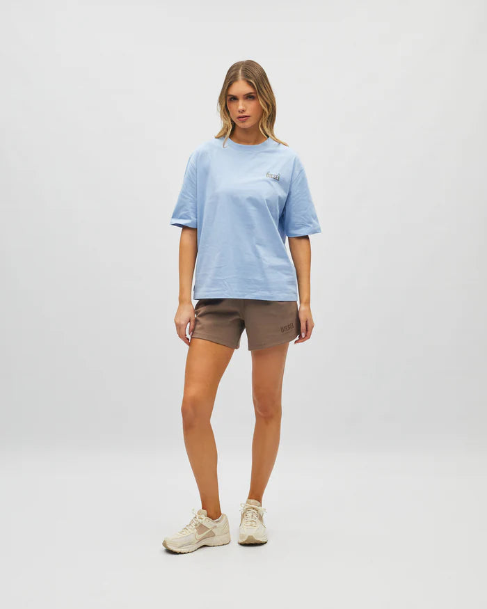 Woman wearing a light blue t-shirt and brown shorts on a white background