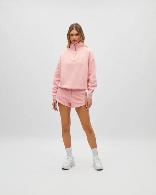 Person wearing a pink outfit with a matching hoodie and shorts on a white background