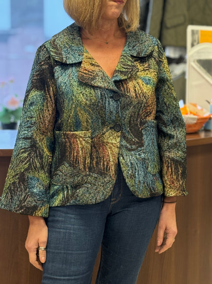 Person wearing a patterned jacket and jeans in an indoor setting