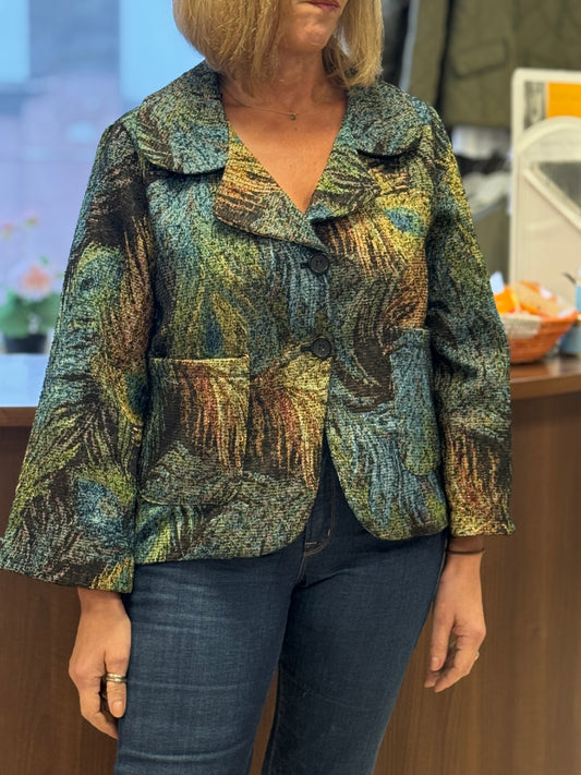 Person wearing a patterned jacket and jeans in an indoor setting